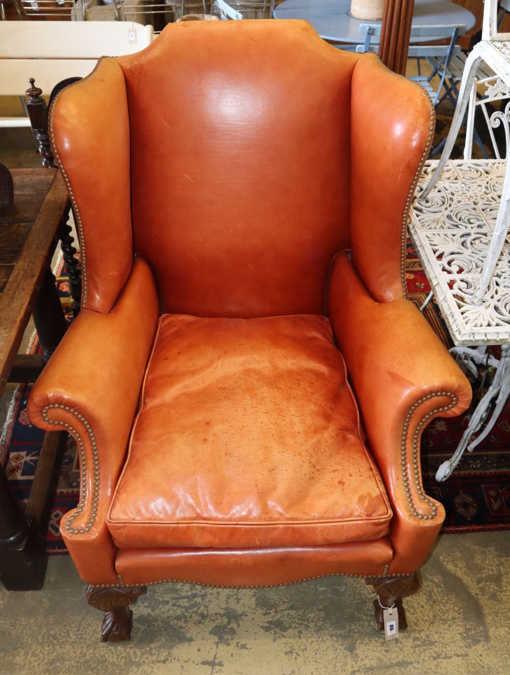 A Georgian style wing chair covered in nail-studded hide